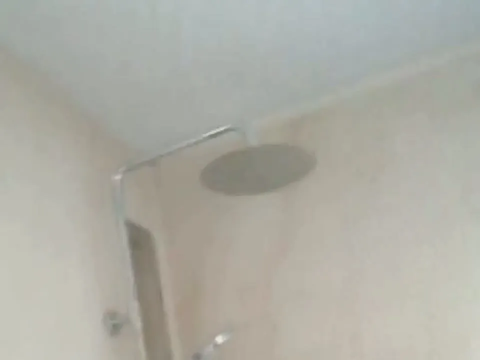 Ducha con columna de lluvia y paredes de porcelánico imitación mármol
