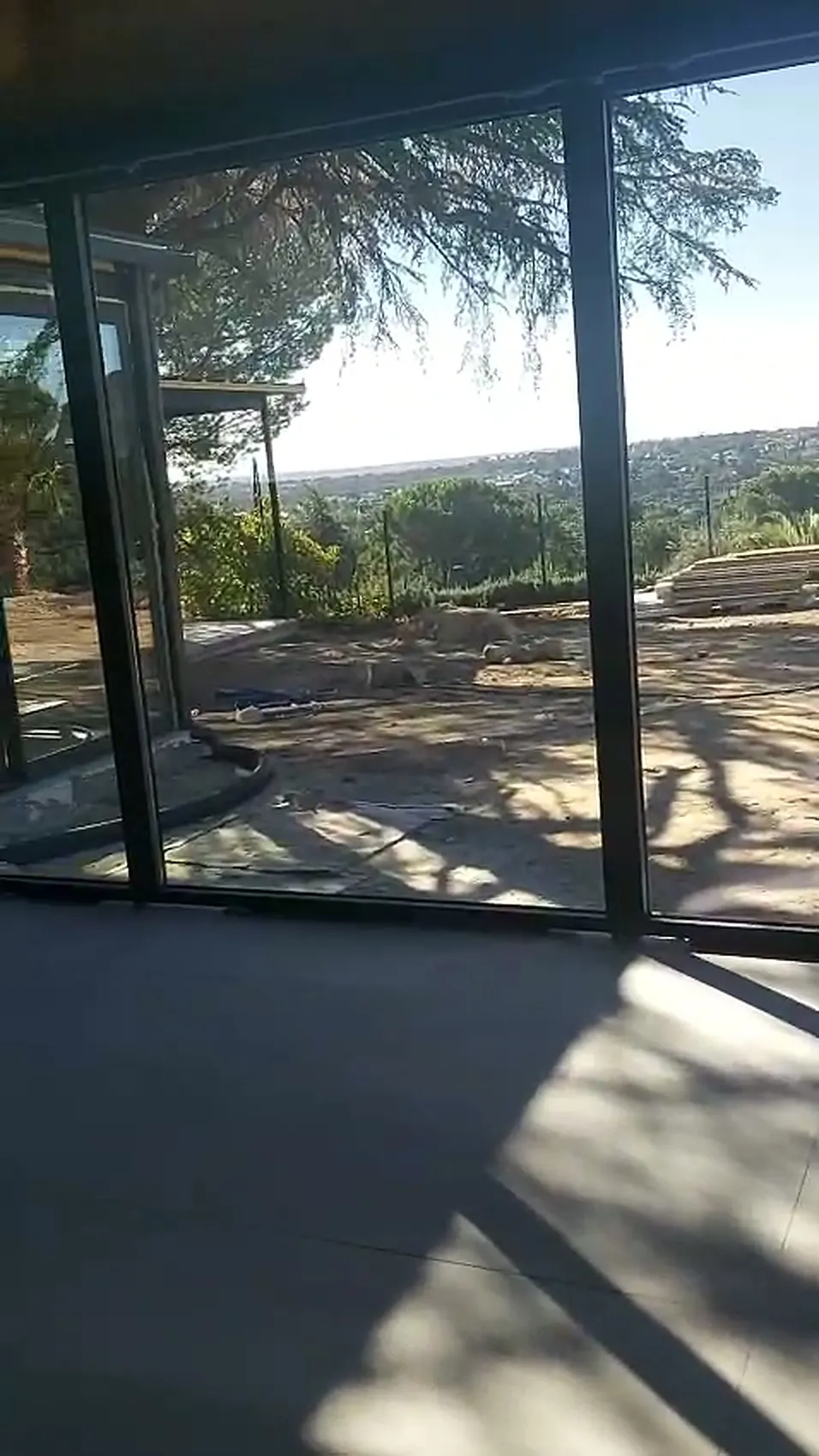 Esquina acristalada del pabellón con vistas al jardín y a la sierra